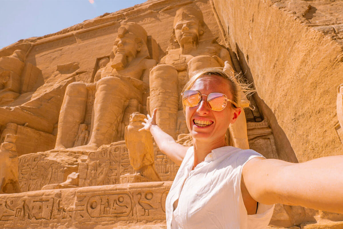 A-wonderful-view-of-a-female-tourist-taking-a-selfie-in-front-of-the-statues-of-Abu-Simbel-Temple-in-Aswan